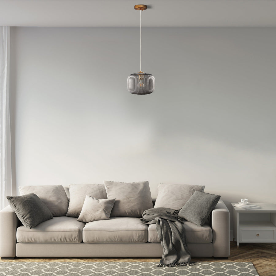 Cygnus Pendant Light Collection features a translucent elongated ribbed glass shade that creates an eye-catching glow. Hanging from a rich gold tone brass finish canopy that enhances its modern sophistication. Place over dining areas, seating areas, and more for a dramatic look. Its versatile look can complement most any room style.